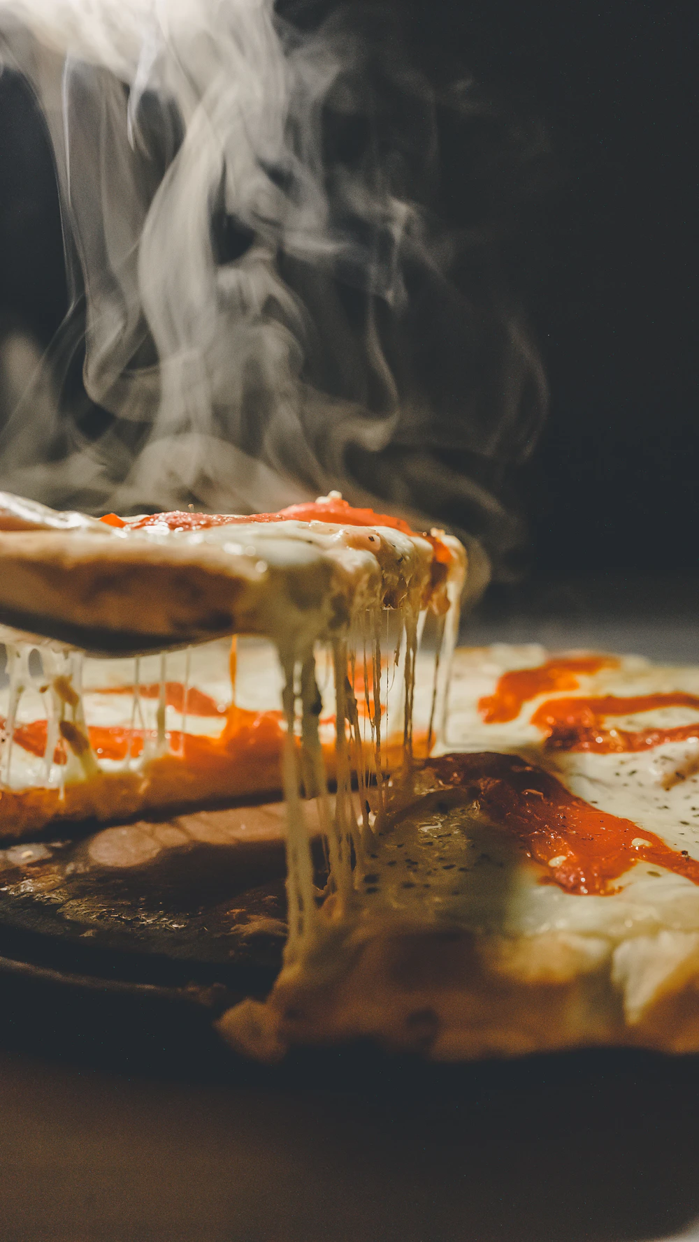 Melted cheese being pulled from a slice