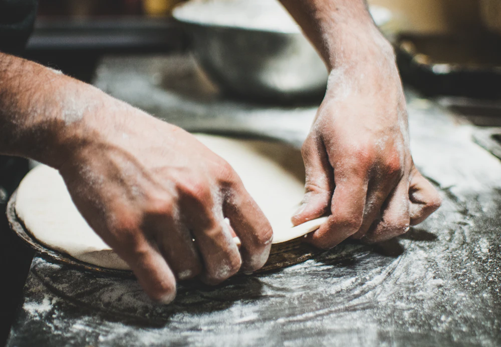 Hands kneading pizza dough