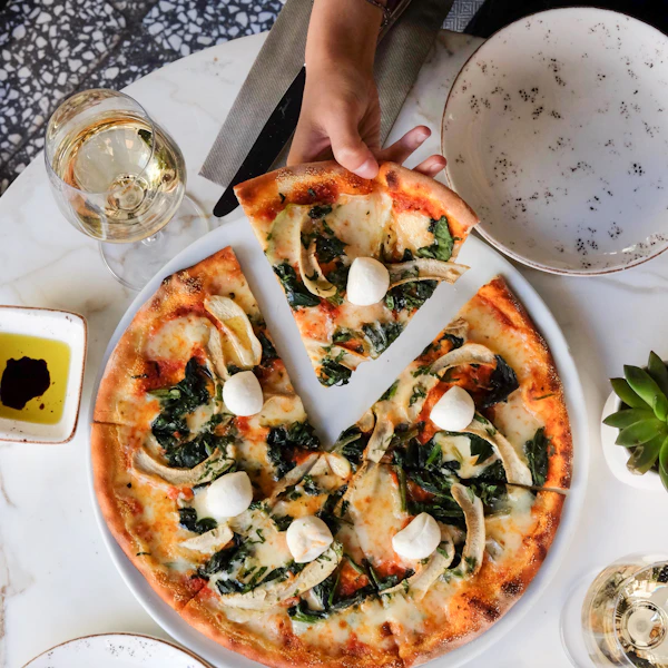 A cheese pizza on a white table