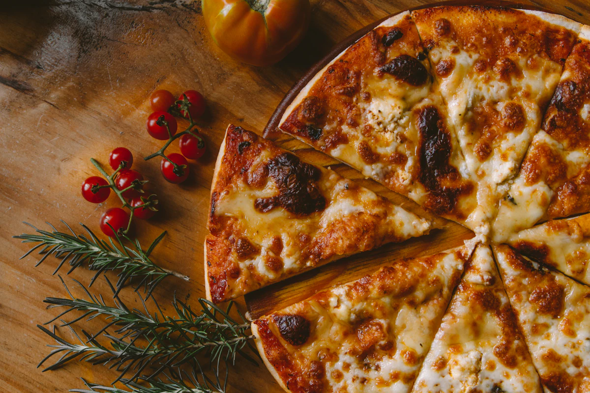 A sliced cheese pizza with cherry tomatoes